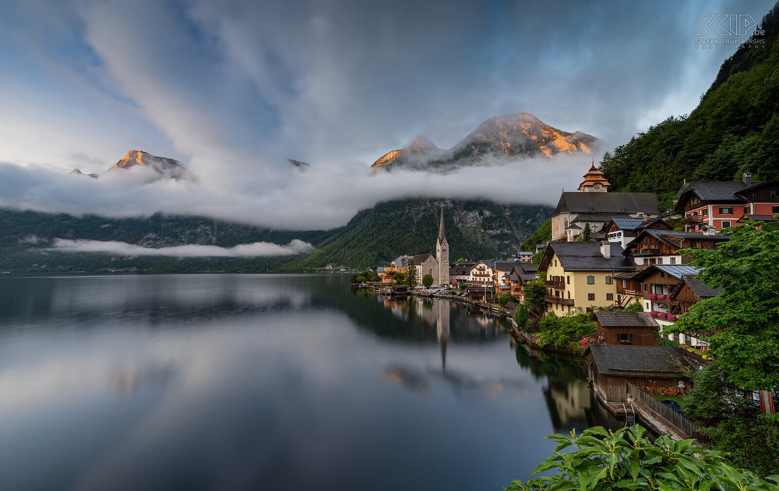 Hallstatt - Alpine glow We stayed one night in the picturesque, famous and popular village of Hallstatt. This village is located between the Hallstättersee and the Dachstein Mountains. In the morning I went out to take pictures. The sunrise was not spectacular and there were a lot of low hanging clouds but for a few minutes a beautiful alpine glow was visible on a couple of mountain peaks. Stefan Cruysberghs